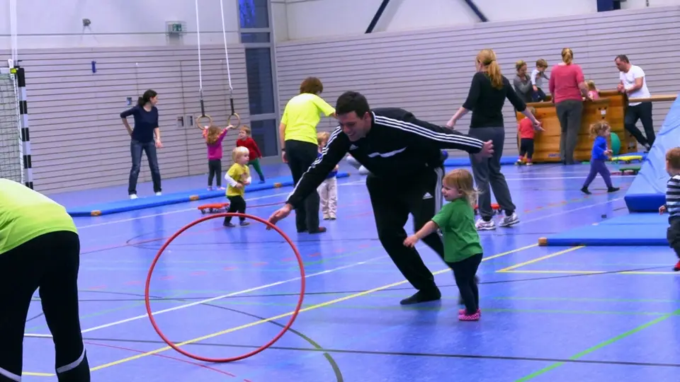 Kinder und Erwachsene beim gemeinsamen Turnen mit Reifen