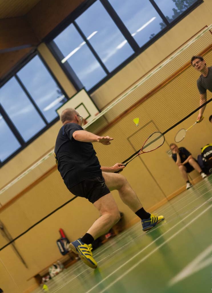 Badmintonspieler des TuS Mosella Schweich spielt einen Federball am Netz in der Sporthalle