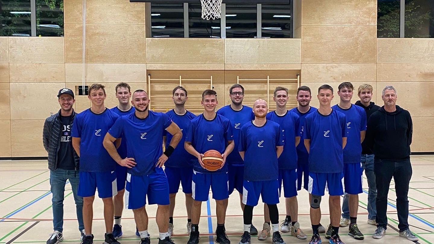 Basketballspieler des TuS Mosella Schweich in blauen Vereinstrikots beim Mannschaftsfoto mit Basketball in der Sporthalle Basketballspieler des TuS Mosella Schweich in blauen Vereinstrikots beim Mannschaftsfoto mit Basketball in der Sporthalle
