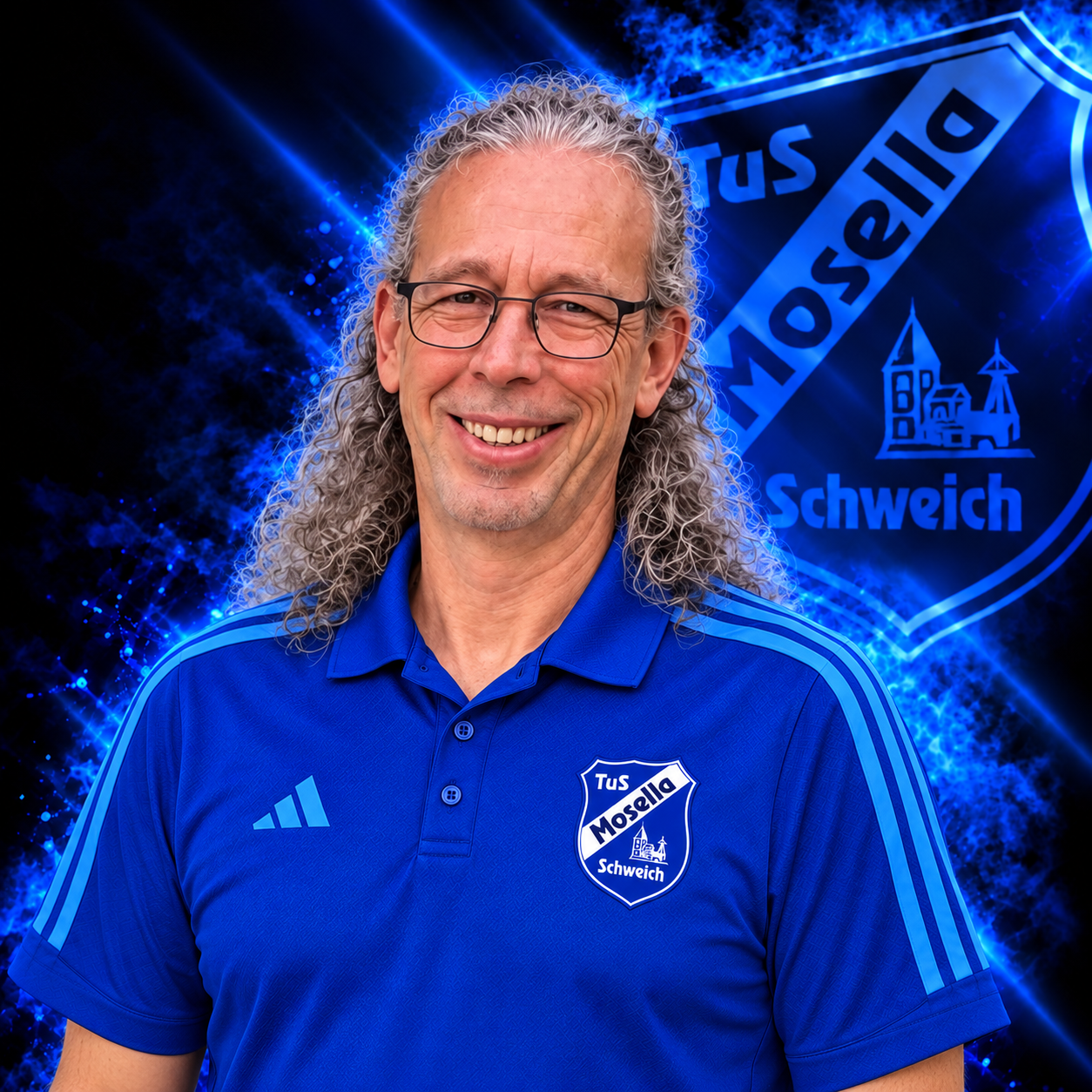 Helmut Winnebeck, Abteilungsleiter Dart beim TuS Mosella Schweich, im blauen Adidas Vereinspolo vor dem Mosella Logo