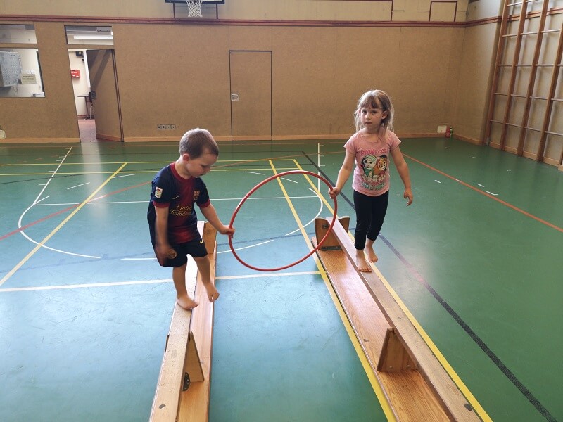 Kinder beim Balancieren mit Reifen in der Turnhalle des TuS Mosella Schweich