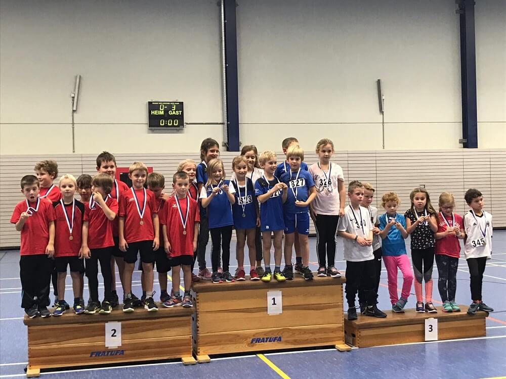 Kinder und Jugendliche mit Medaillen beim gemeinsamen Foto in der Sporthalle