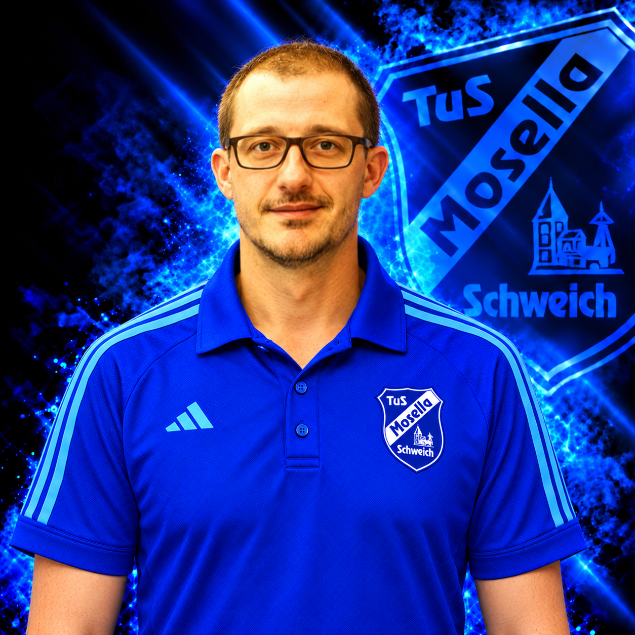 Torsten Mahren, Abteilungsleiter Leichtathletik des TuS Mosella Schweich, im blauen Adidas Polo mit Mosella Wappen vor dem blauen Vereinshintergrund