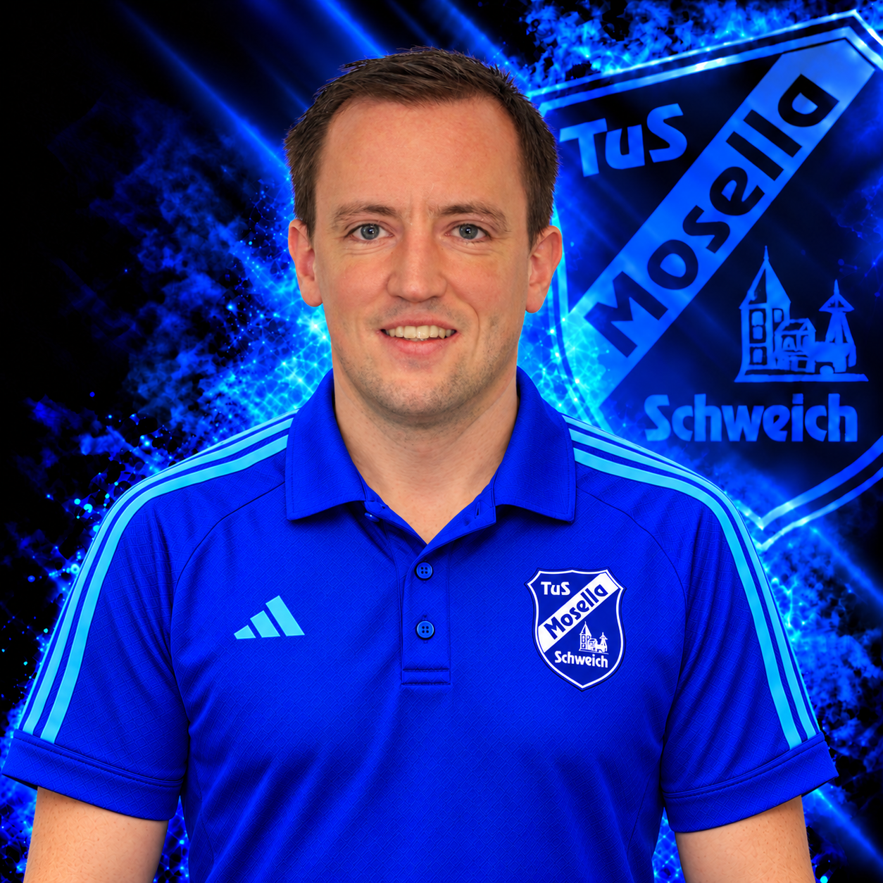 Thorsten Stracker, Ansprechpartner Tennis beim TuS Mosella Schweich, im blauen Adidas Polo mit Vereinswappen vor dem Mosella Hintergrund